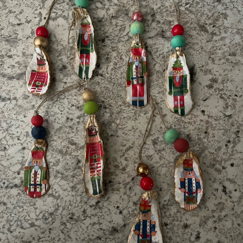 Set of six oyster shell nutcracker ornaments .